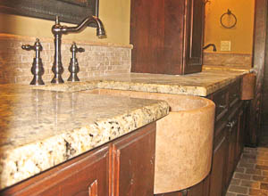 Curved apron-front undermount sink in a granite kitchen countertop